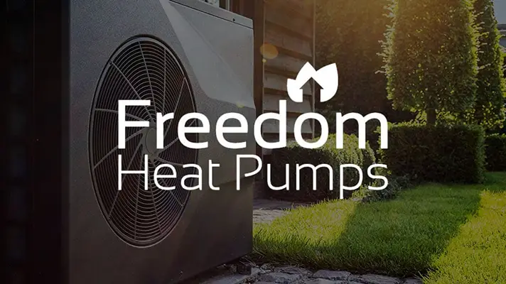 Air source heat pump outside of a house with Freedom Heat Pump logo overlay.